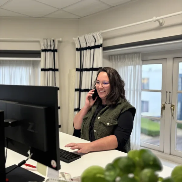 Capaciteitsplanner Jill aan de telefoon achter haar bureau - Verhalen