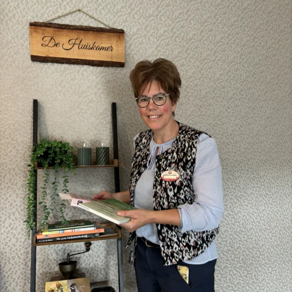 Verzorgende IG Marcia met boeken voor De Huiskamer - Verhalen